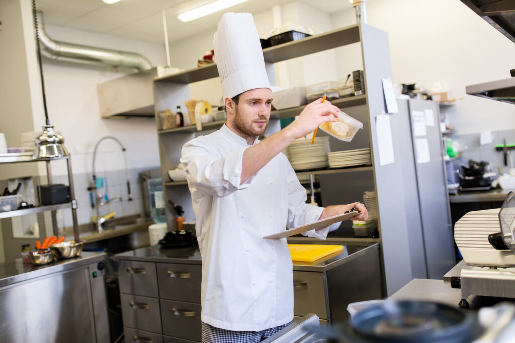 chef with clipboard doing inventory at kitchen